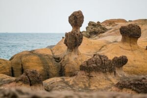 Scenic eroded rock formations by the sea at Yehliu Geopark, Taiwan, showcasing natural beauty.