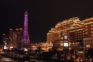 Vibrant night view of the Parisian Macao featuring its iconic illuminated Eiffel Tower replica.