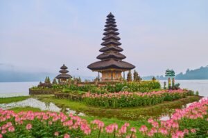 Beautiful Ulun Danu Beratan Temple in Bali, surrounded by colorful flowers and a serene lake.