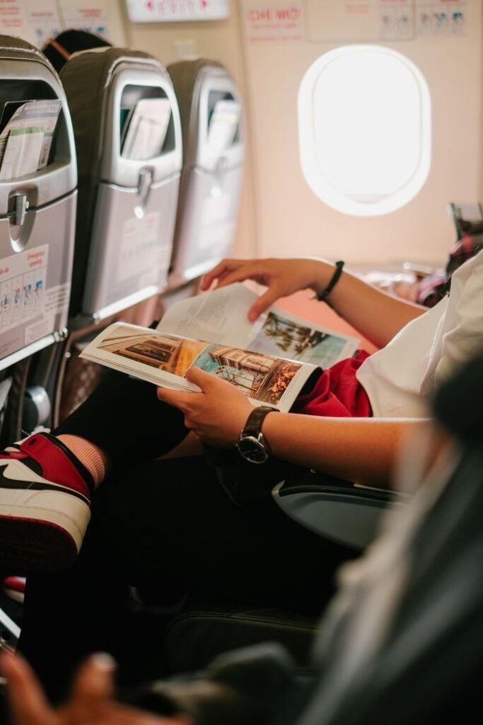 pexels photo 13404722 13404722 Person reading a magazine while seated in an airplane, offering an in-flight experience.
