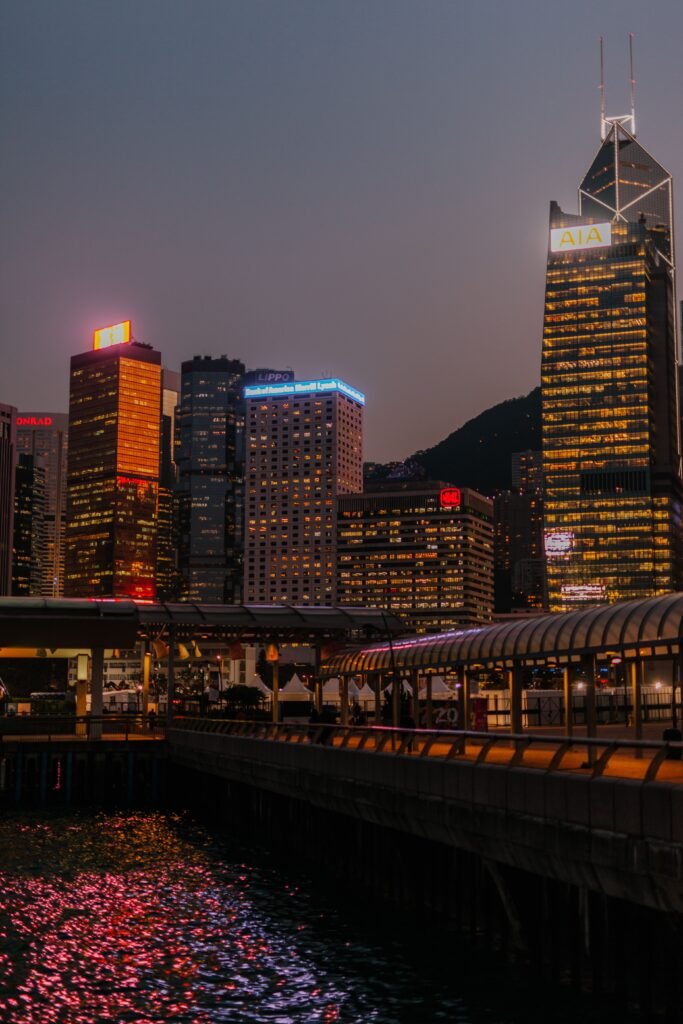 Captivating view of Hong Kong's illuminated skyscrapers reflecting in water at night.